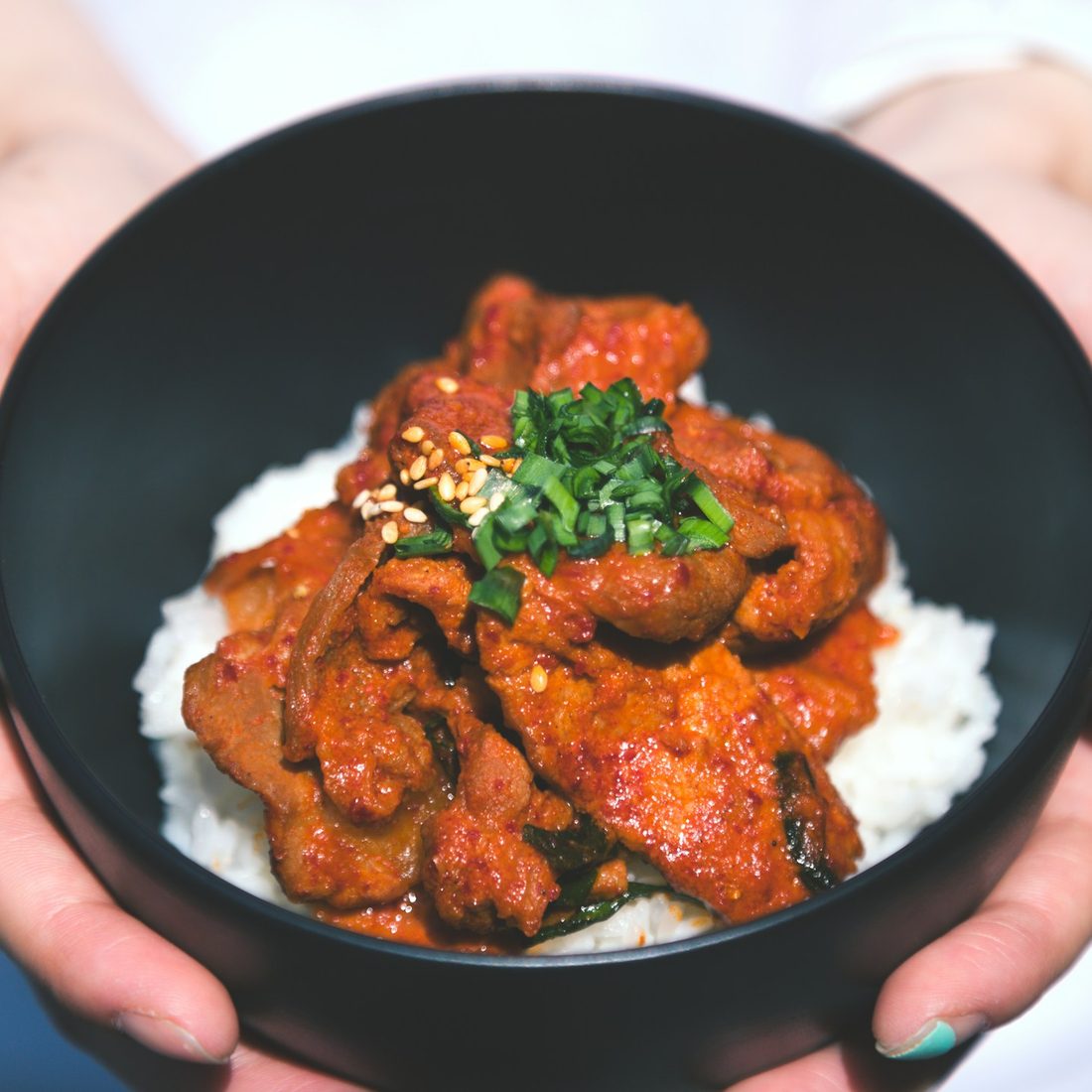 A glazed, char-grilled dish served over rice