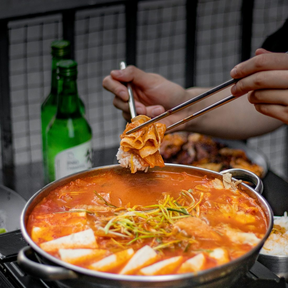 A bubbling pork bone soup pot at the table, ready to share